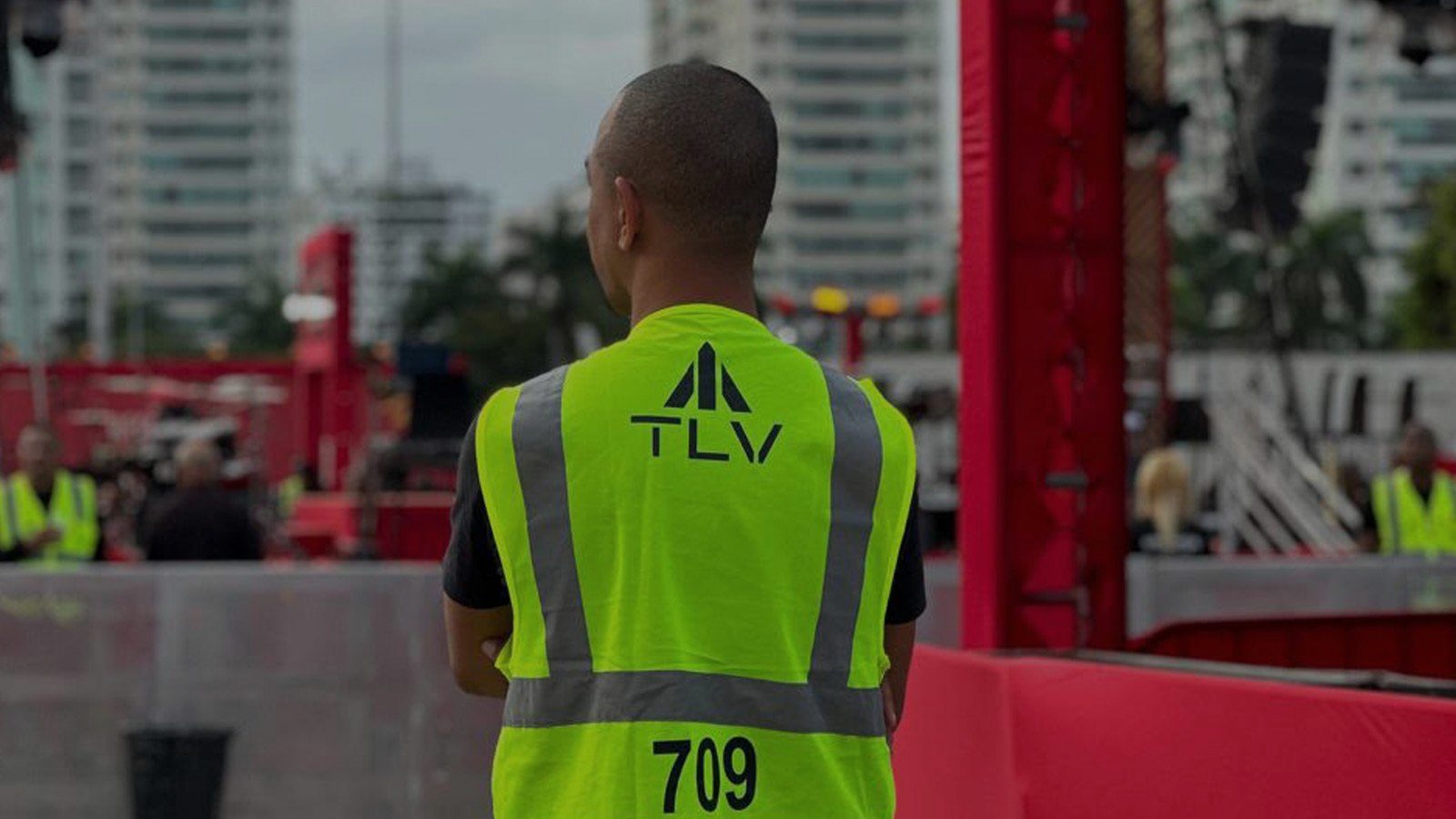 Profissional do Grupo TLV com colete da marca em evento